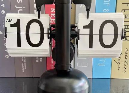 Μαύρο επιτραπέζιο flip ρολόι σε ράφι με βιβλία